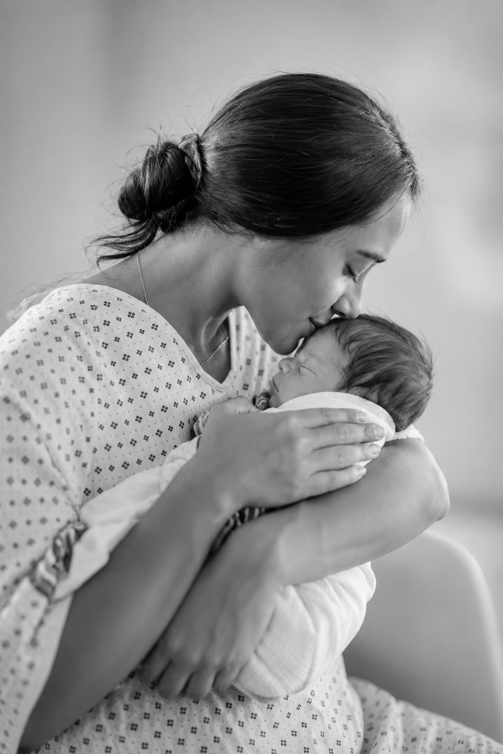 dark B/W · mother kissing newborn